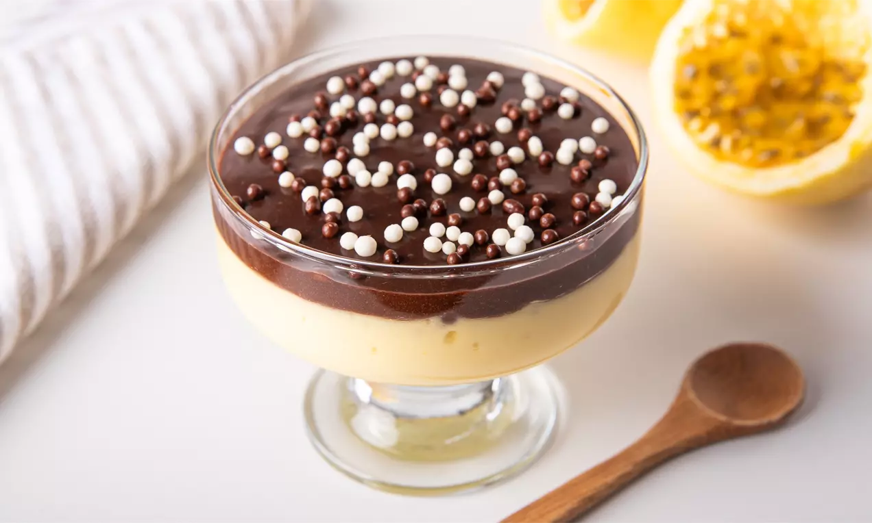 Mousse de maracujá com ganache de chocolate, amarelo-creme com cobertura brilhante marrom, sementes de maracujá e hortelã em taça